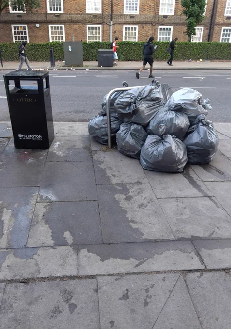 Pile of bin bags in a street after street cleaning