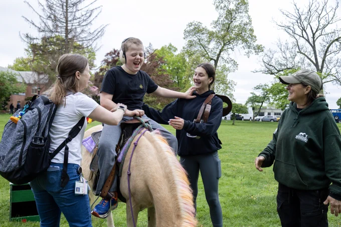 Colton rides a pony wearing noise canceling headphones