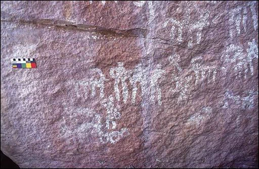 Rock panel decorated with white paintings of people and animals.