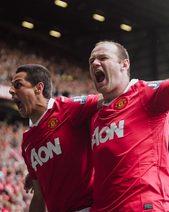 Chicharito and Wayne Rooney celebrating on the pitch at Old Trafford.