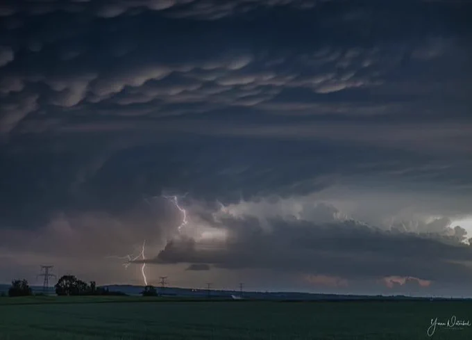 Photographie d’un ciel orageux et chargé, avec un éclair visible.