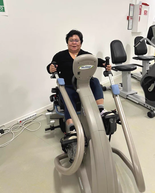 Woman using a NuStep T5XR recumbent cross trainer in a wellness gym setting.