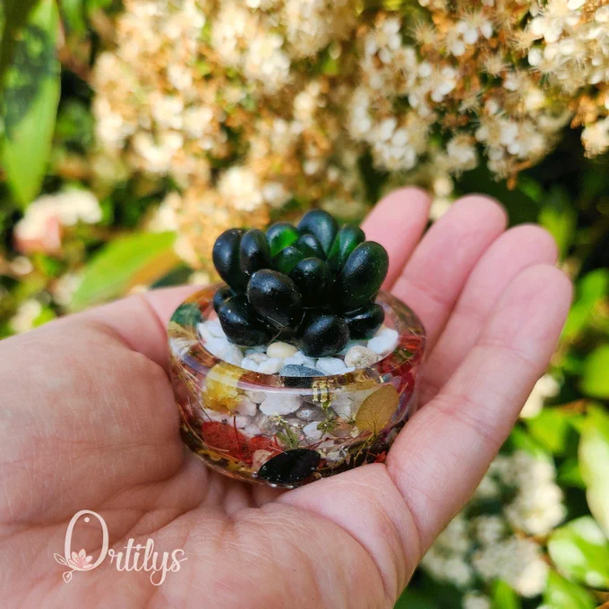 une petite succulente verte en résine dans un petit pot, cela tient dans la main