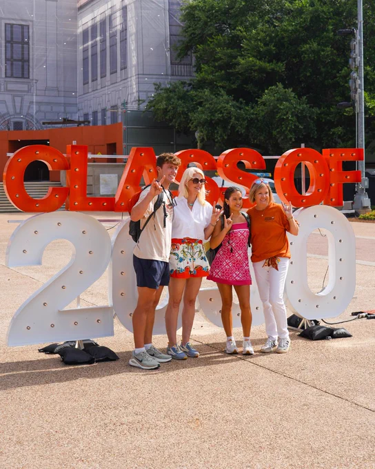 Group stands in front of a marquee sign that says \"Class of 2030\" to celebrate UT Austin orientation. 