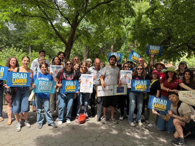 Standing with a large group of canvassers holding up campaign signs.