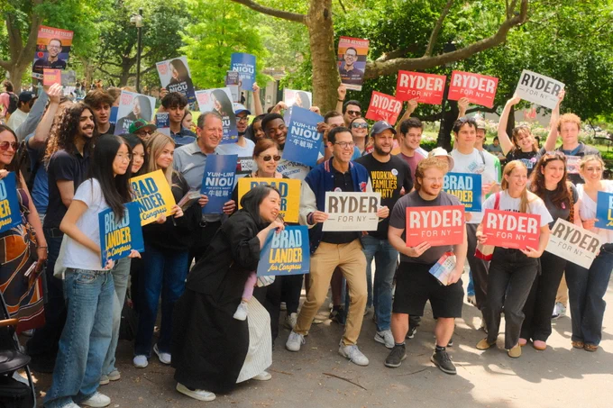 Standing with a large group of canvassers holding up campaign signs