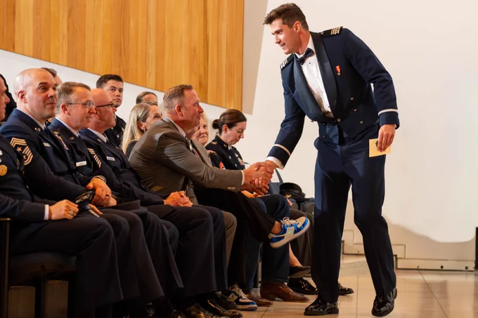 A U.S. Air Force Academy male cadet shakes hands with a man at the Space Force Patching Ceremony.