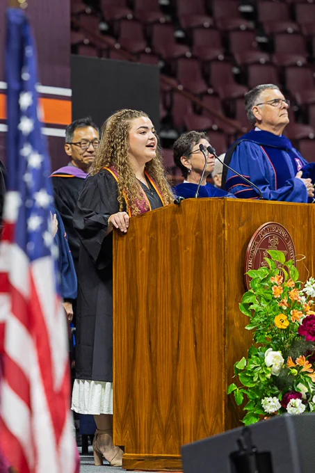 Graduate speaking at podium on the stage