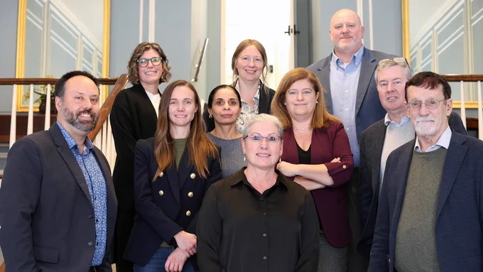 Flaum Eye Institute researchers posing for a group photo on stairs. 10 people, four males and six females.