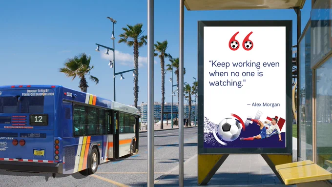 Photo of a Broward County Transit bus stop with a large advertisement display featuring a quote by Alex Morgan that reads, “Keep working even when no one is watching.” The display includes soccer-themed graphics with a soccer ball and player illustration. A BCT bus is visible in the background, with palm trees and a sunny sky surrounding the stop.