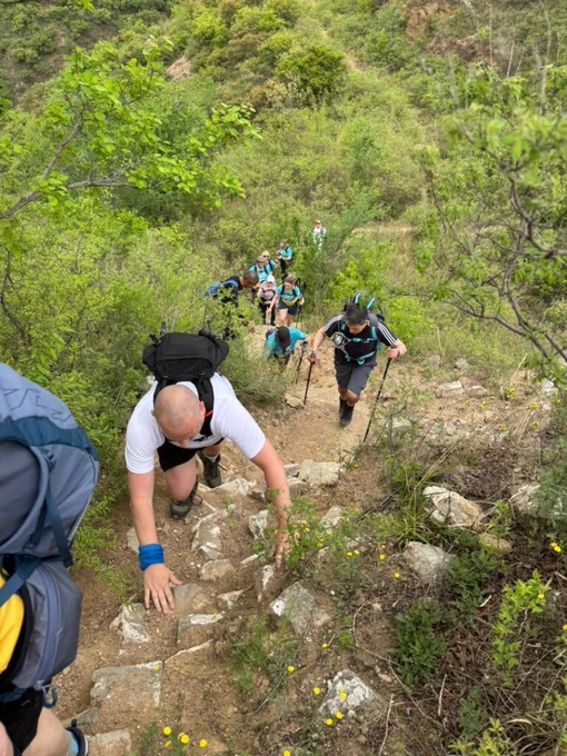 A group of people hiking up a steep mountain path