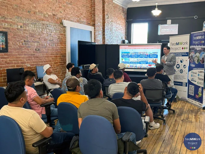 Participants sit in a workshop session at Collège Boréal while a facilitator presents information on a screen about workplace health, including eye safety, with TeaMWork Project materials displayed nearby.