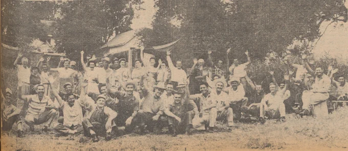 A black and white photograph of furniture workers waving to the camera.