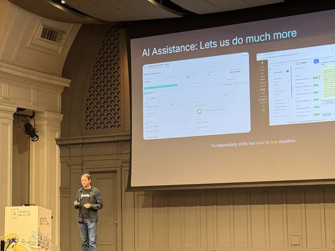 Matt on stage, slide reads AI assistance: lets us do much more