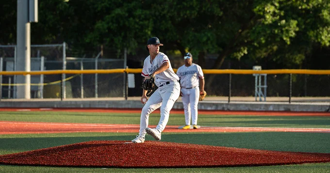 Yard Dogs pitcher mid-pitch, with his leg up and his arm back to throw.