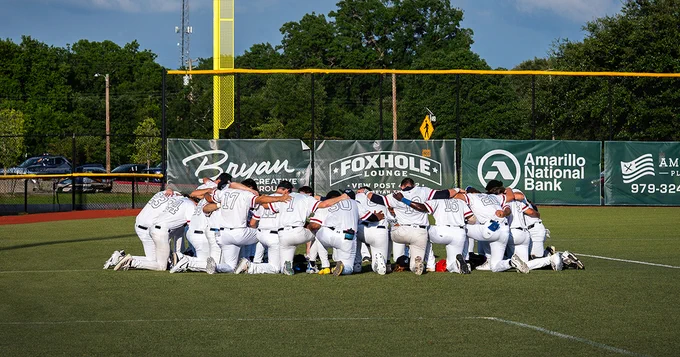 Yard Dogs players kneel in a huddle before a game.