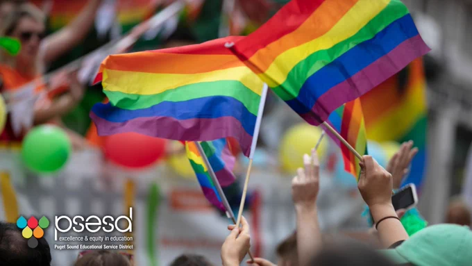 Rainbow flags wave in a crowd