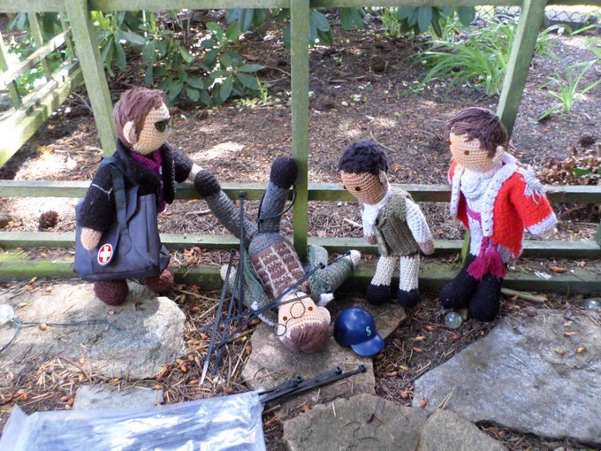 Crochet dolls of Owen Harper, Cicero & Edmund Hewlett looking at a fallen Hermann Gottlieb, who is tangled in zip ties. 