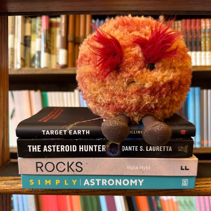 A stack of books with a fluffy Mars Jellycat sitting on top. The books are
Target Earth: Meteorites, Asteroids, Comets, and Other Cosmic Intruders That Threaten Our Planet by Govert Schilling
The Asteroid Hunter: A Scientist's Journey to the Dawn of our Solar System by Dante Lauretta
Rocks: A Guide to the Stones Around Us and the Stories They Tell by Vojta Hybl
Simply Astronomy (DK Simply)