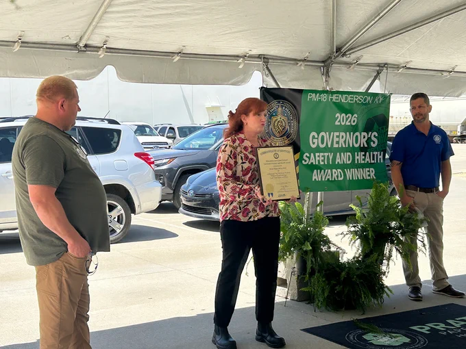 KYSAFE Director Lynn Whitehouse photographed holding the Governor's Safety and Health Award plaque presented to Pratt Paper employees.