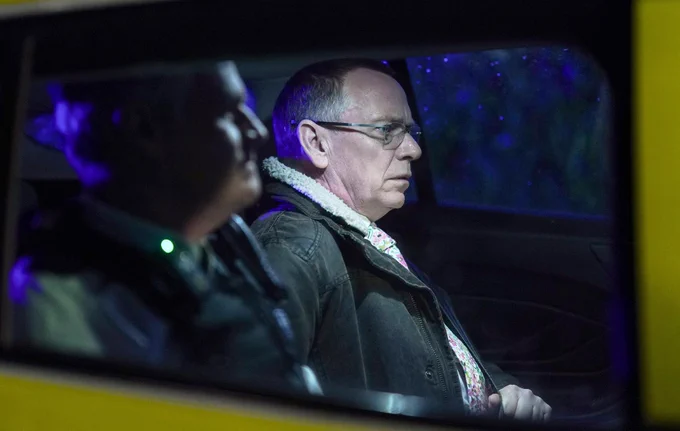 EastEnders' Ian Beale looks gloomy, sat in a police car beside an officer.