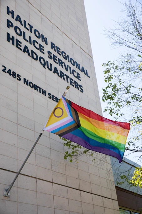 2SLGBTQIA  flag flying on the Halton Regional Police Service Headquarters building.