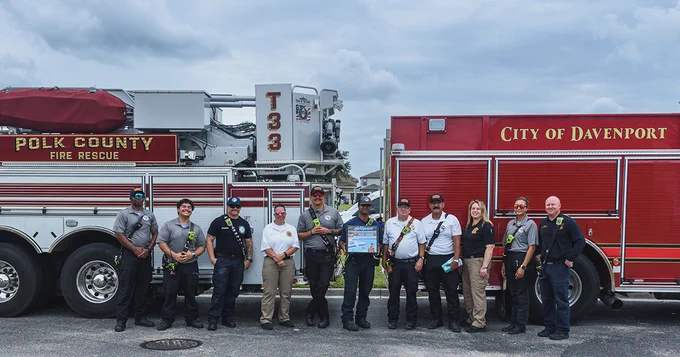 PCFR and DFD members posing for a photo in front of PCFR’s Tower 33 and DFD’s Engine 1.