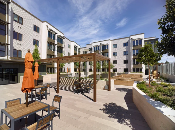 Photo of completed building and courtyard with tables and chairs