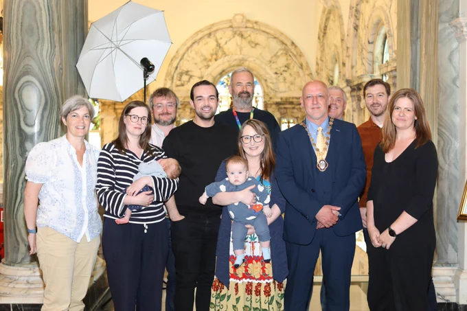 From left to right: Alliance Cllr Tara Brooks, Cllr Fiona McAteer, Cllr Emmet McDonough-Brown, Cllr Micky Murray, Cllr David Bell, Cllr Christine Bower, Cllr Hedley Abernethy, Cllr Michael Long, Cllr Sam Nelson, and Cllr Jenna Maghie at top of inside Belfast City Hall staircase.