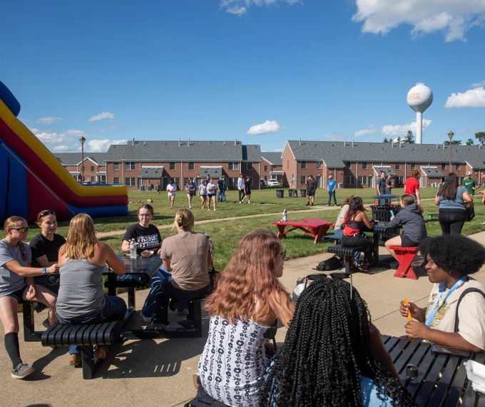 Students outside at the apartments for move-in weekend housing activities.
