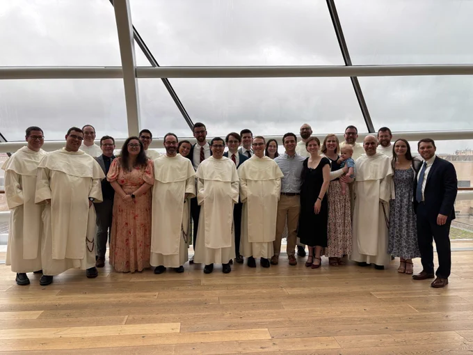Fr. Raphael Arteaga, O.P. '19 surrounded by PC alumni