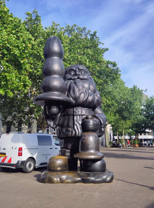 Statue of Santa Claus holding a suspicious object.