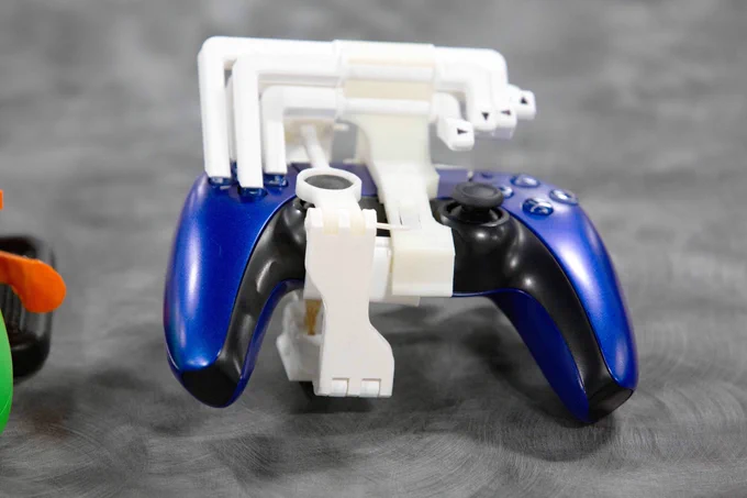 Pictured is a photo of a Playstation video game controller that have been modified with snap-on modifications so they can be used by everyone.