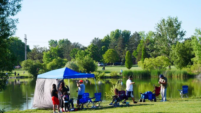 Families set up around the lake for the fishing derby at Sanborn Park.