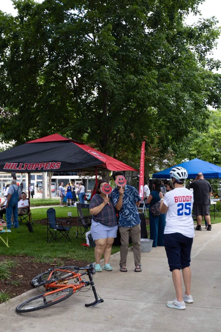 Hilltoppers and community members participated in the annual Duncan Hines Days. Image features guests at the WKU alumni tent with Big Red fans over their face.