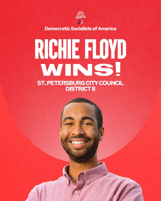 Democratic Socialists of America. Richie Floyd wins! St. Petersburg Council District 8. Photo of Richie Floyd. Photo of Richie Floyd, a confident young Black man wearing a light red Oxford shirt. He has short hair and a short beard and mustache, and smiles warmly at the viewer.