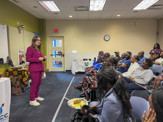 Standing at the front of a room of seated attendees, Rep. McBride speaks to attendees at the Delaware Africa Chamber of Commerce's Africa Day celebration. 