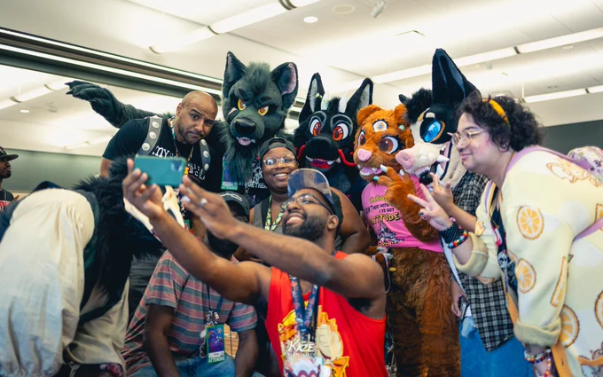 A group photo at a meetup of various attendees and fursuiters at Anthrocon 2025
