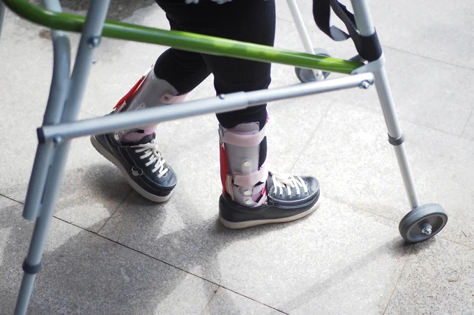 person walking with walker and support