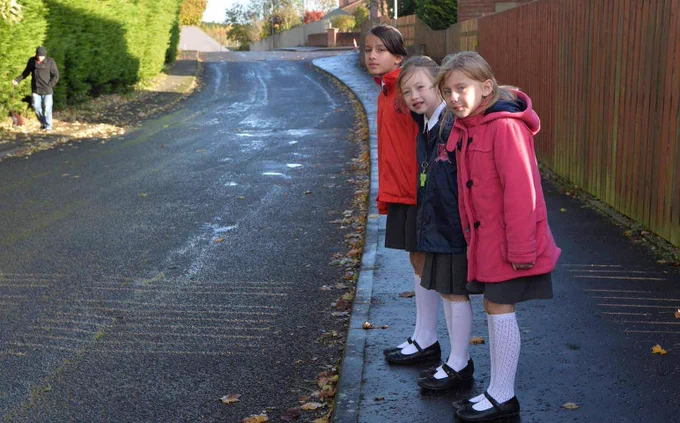 Image of children standing at a kerb side waiting to cross the road.