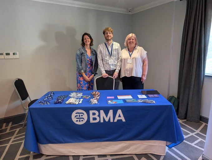 Three people stood in front of a BMA Cymru stand