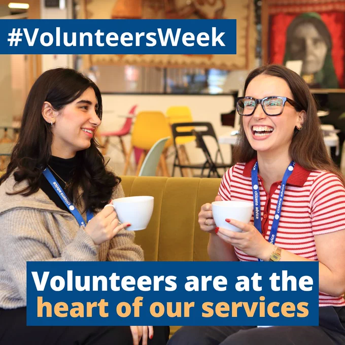 2 smiling Citizens Advice volunteers wearing their lanyards, sitting down on a sofa and holding mugs. Text reads “Volunteers are at the heart of our services” with the hashtag #VolunteersWeek