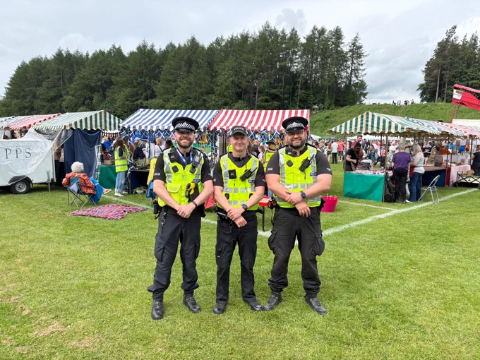 3 male police officers standing with a Gala in the background