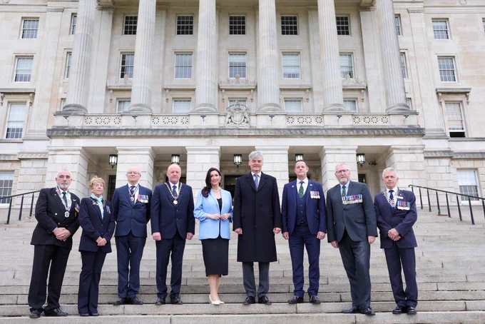 Image of nine people - including deputy First Minister Emma Little-Pengelly - standing on the steps outside Parliament Buildings in Belfast