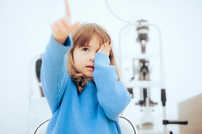 A young girl pointing to letters during an eye exam