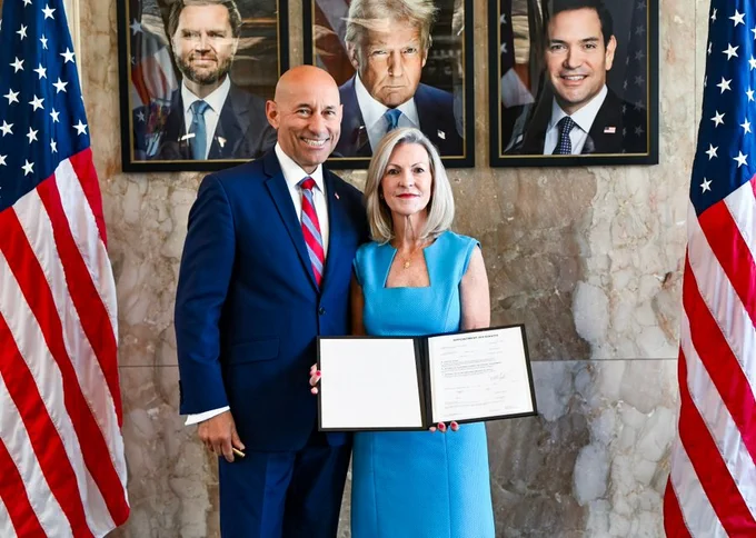 Le nouveau secrétaire d’État adjoint aux Affaires africaines, Frank Garcia, pose avec un membre de sa famille après sa prestation de serment, tenant le document officiel de sa nomination.