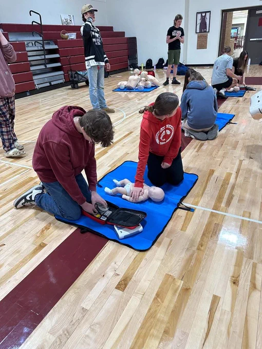 multiple students performing CPR on babies and the others getting AED ready