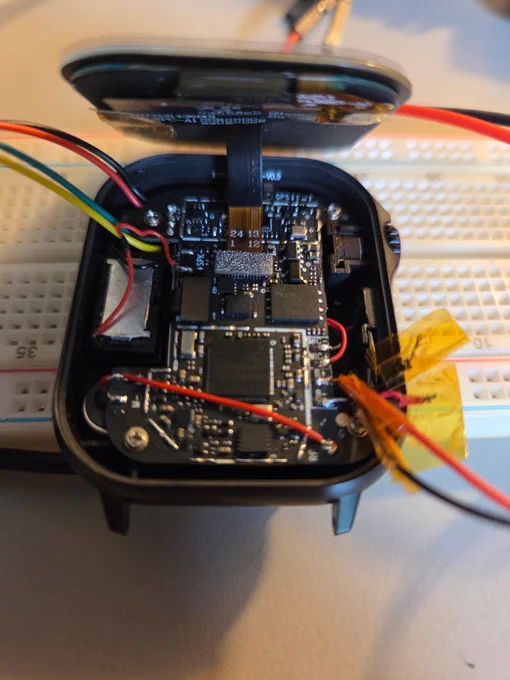 The internals of the PineTimePro plus a few additional wires for debugging. The SWD wires are on the top left and the power on the bottom right (the battery is currently disconnected).