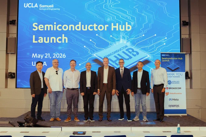 A group of eight people stand on stage in front of a large screen displaying "Semiconductor Hub Launch" with the date May 21, 2026. Behind them is a banner listing partners including UCLA Samueli School of Engineering, Broadcom, GlobalFoundries, IBM, Meta, and Synopsys.