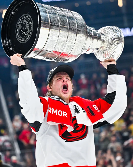 Jackson Blake lifting the Stanley Cup on ice in a Hurricanes uniform